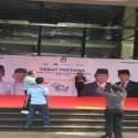 Melintas Depan Lokasi Acara Debat, Warga Sempatkan Berfoto Di Depan Banner Paslon Pilpres