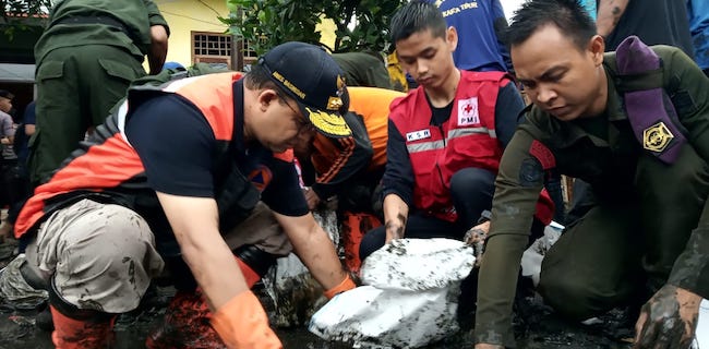 Anies Bantu Warga Makasar Pungut Lumpur Sisa Banjir