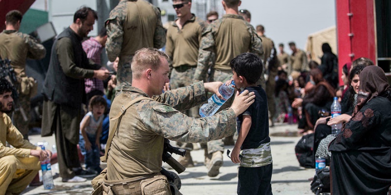 Tentara AS memberi minum seorang anak Afghanistan saat kericuhan di Bandara Kabul/Net