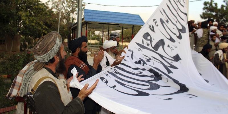 Pejuang Taliban membaca doa sebelum mengibarkan bendera di Istana Emirat Islam Afghanistan di Kabul/Net