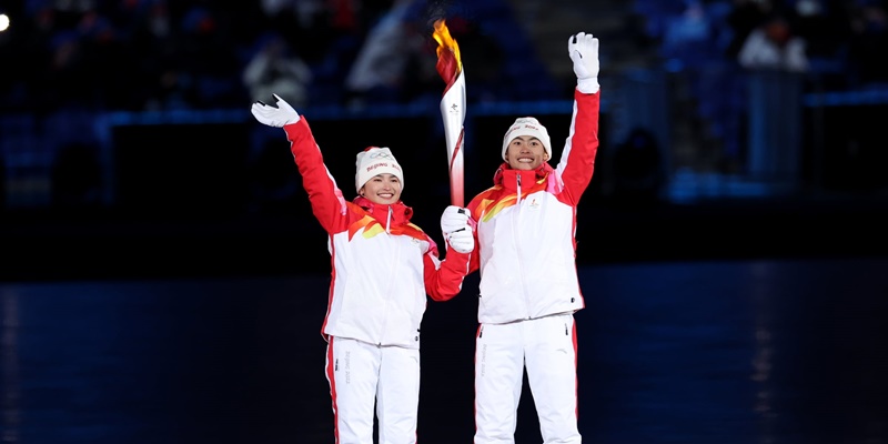 Atlet Tiongkok asal Uighur, pemain ski lintas alam Dinigeer,  Yilamujiang, bersama atlet gabungan Nordik Zhao Jiawen yang menyalakan kuali Olimpiade Beijing 2022/Net.