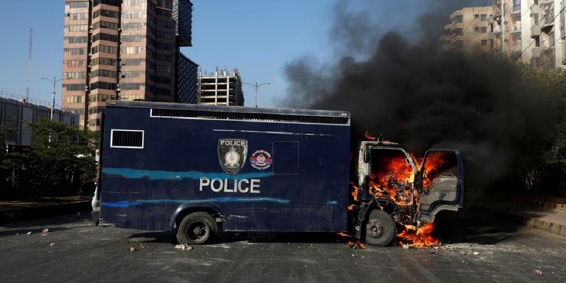 Van polisi dibakar oleh pengunjuk rasa, yang memprotes penangkapan mantan Perdana Menteri Imran Khan di Karachi, Pakistan, 9 Mei 2023/Foto: Reuters