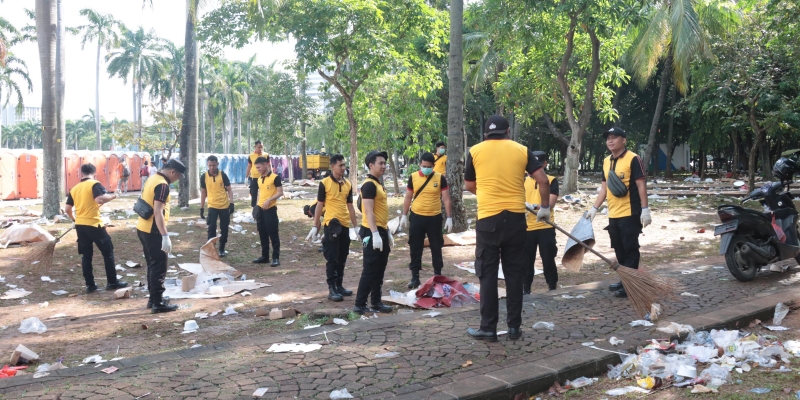 Momen Anggota Polisi Bersih-Bersih Sampah di Monas