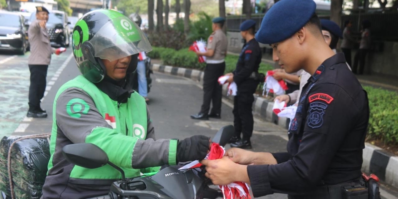 Polisi Bagikan Ribuan Bendera Merah Putih di Jakarta