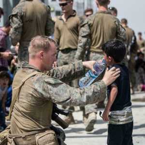 Tentara AS memberi minum seorang anak Afghanistan saat kericuhan di Bandara Kabul/Net