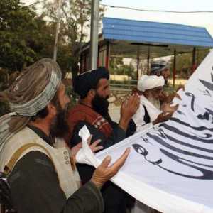 Pejuang Taliban membaca doa sebelum mengibarkan bendera di Istana Emirat Islam Afghanistan di Kabul/Net