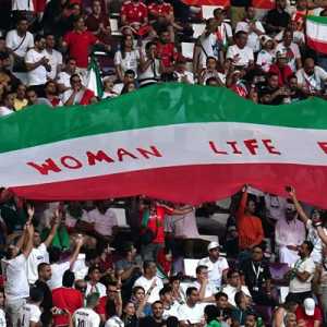 Fans Iran di tribun mengibarkan bendera Iran bertuliskan Woman Life Freedom selama pertandingan melawan Inggris di Khalifa International Stadium, Doha, Senin 21 November 2022/Net