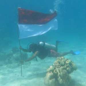 Duta Besar RI untuk Kuba, Nana Yuliana, mengibarkan bendera Merah Putih di dasar Laut Karibia, Kamis (17/8)./Ist