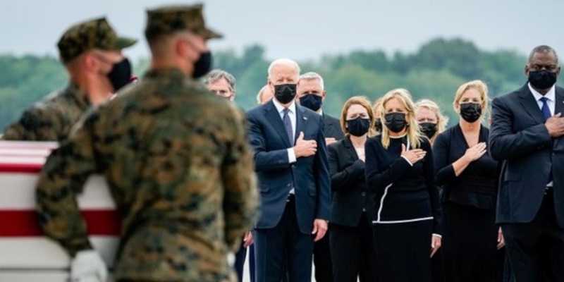  Presiden Joe Biden, didampingi istrinya, Jill Biden, memberi penghormatan saat peti jenazah sebelas militer tiba di Pangkalan di Dover, Delaware. 