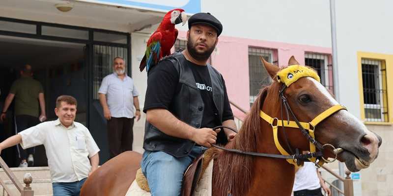 Ada yang menunggang kuda dengan burung beo di pundaknya saat menuju tempat pemilihan suara di Denizli, Türkiye, 28 Mei 2023/Net